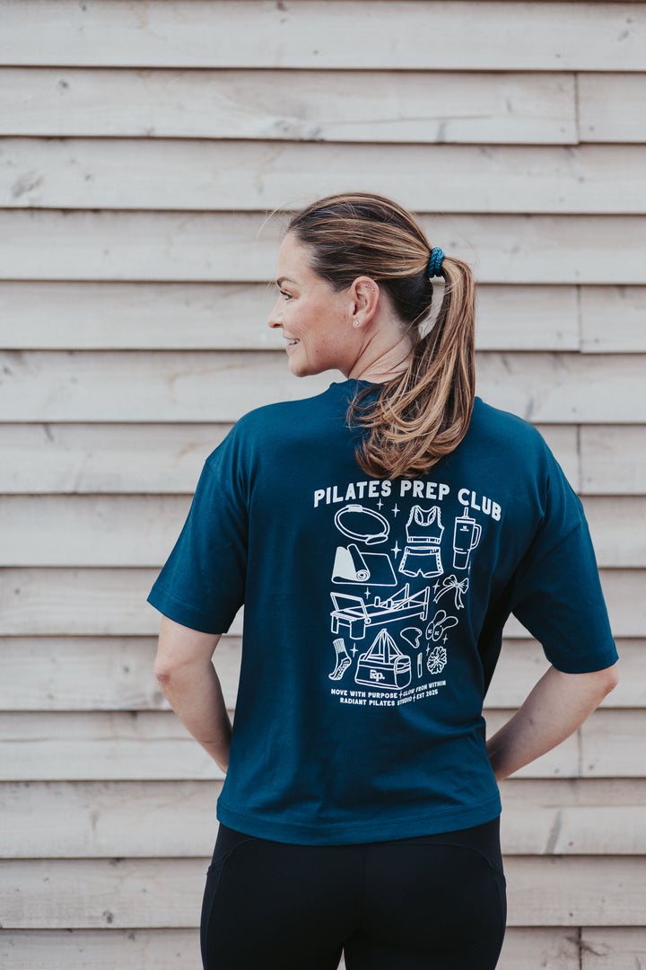 Fern wearing the navy Pilates Prep Club T-shirt, showing the illustrated back print