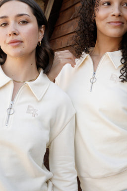Cream Radiant quarter-zip with contrast piping and embroidered logo, photographed by Alicia