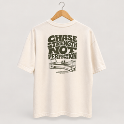 Cream Radiant Pilates T-shirt on wooden hanger, showing olive Chase Strength Not Perfection back graphic