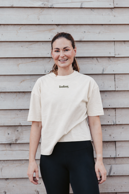 Fern wearing the cream Radiant Pilates oversized T-shirt with small olive chest logo